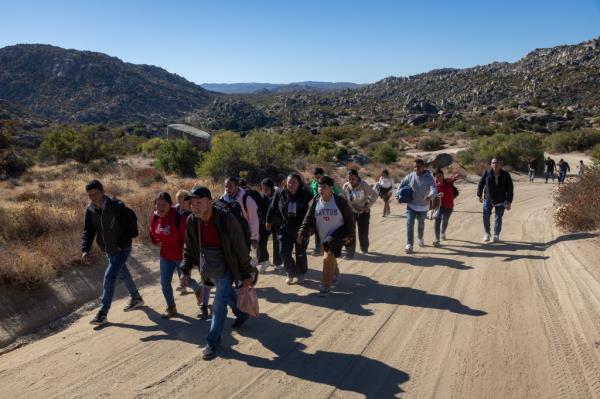 Colombian migrants walk along a desert road after crossing the U.S.-Mexico on September 22, 2024 near Jacumba Hot Springs, California.